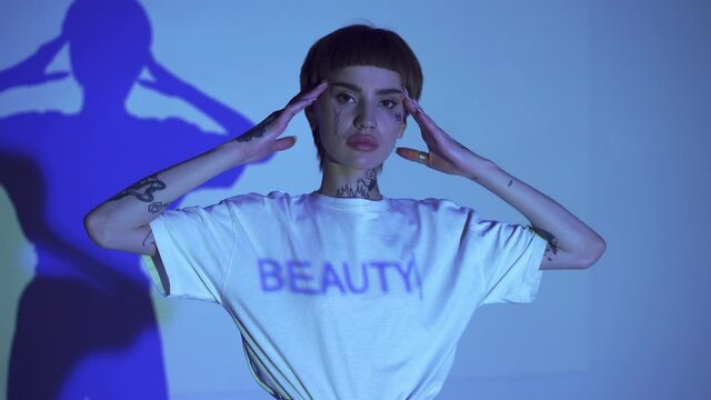 Lettering beauty on t-shirt of tattooed woman on blue background 