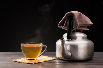 organic hot tea placed on a wooden table on a black background
