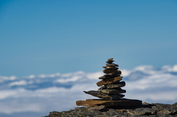 Stone men in the snowy swiss mountains with sea of fog and blue sky 