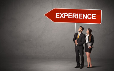 Fototapeta premium Young business person in casual holding road sign