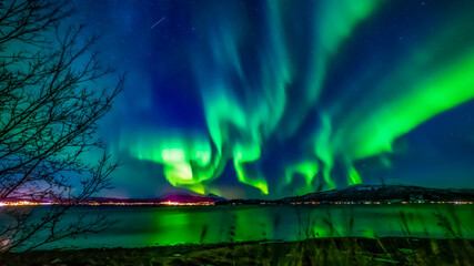 Nordlichter in Troms, Norwegen. Aurora Borealis spiegelt sich im Fjord und leuchtet über den schneebedeckten Bergen. the lady dance in the sky, northern light - obrazy, fototapety, plakaty