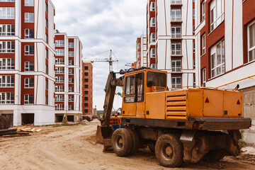 Excavator levels the ground on a construction site