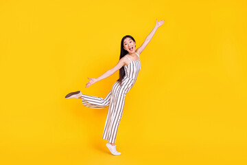 Fototapeta na wymiar Full length body size photo woman in overall laughing cheerful with opened hands isolated bright yellow color background