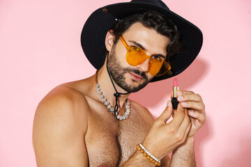 Young shirtless man showing lipstick and looking at camera