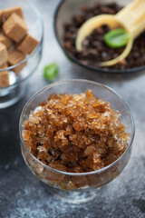 Close-up of a glass bowl with italian coffee granita, vertical shot on a grey stone background, selective focus