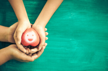 A hand holding red heart.She is Left  right hand holding it on blue background.heart health, happy...