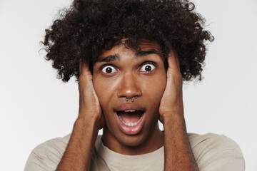 Young black man expressing surprise while holding his head