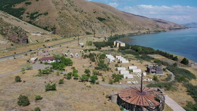 Aerial footage unfinished, abandoned buildings in nature. Near lake Sevan, Armenia. In background mountains.  Highway near Sevan lake.