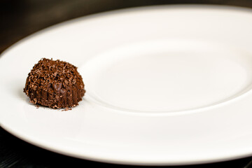 Chocolate truffle, single, on a plate at a restaurant