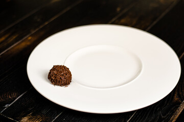 Chocolate truffle, single, on a plate at a restaurant