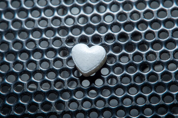 Background with a tablet in the shape of a heart on a dirty floor. Medicines for the heart and to...