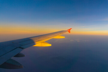 Wing of aircraft on sky with cloud sunset twilight