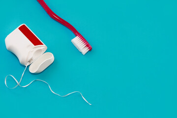 red toothbrush and dental floss for brushing teeth