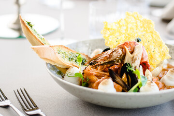 Fish stew with lobster, prawns and seafood foam at a restaurant