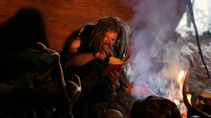 Prehistoric man read book in cave