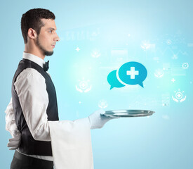 Handsome young waiter in tuxedo holding healthcare icons on tray