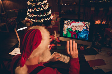 Photo of sweet pretty mature man dressed santa costume speaking modern gadget waving arm indoors home room