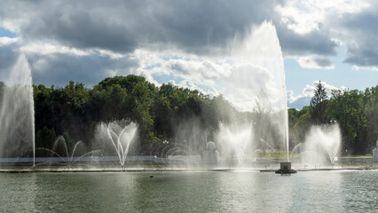 Water from the fountain. Top of high water stream of fountain behind cloudy sky. Fountain in river against dramatic sky.