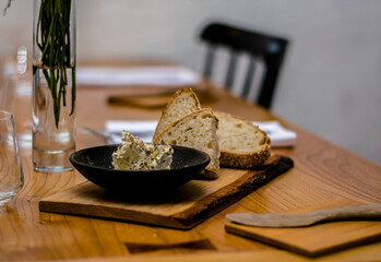 Bread and butter on a wooden plate at a restaurant