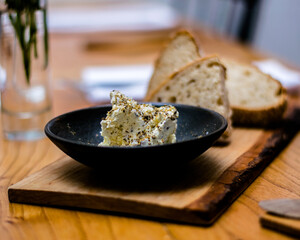 Bread and butter on a wooden plate at a restaurant