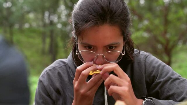 Woman smelling pine bolete mushroom in woods