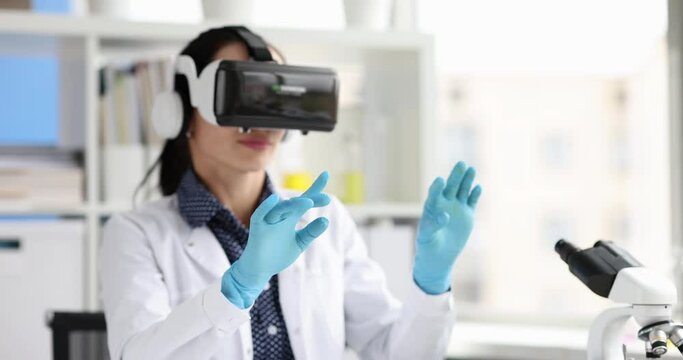 Woman biologist in virtual reality glasses waving hands in laboratory 4k movie