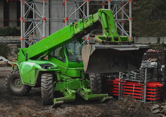 excavator, construction car manita with a bucket at work, green color, clay and construction industry, hydraulic system, car industry background