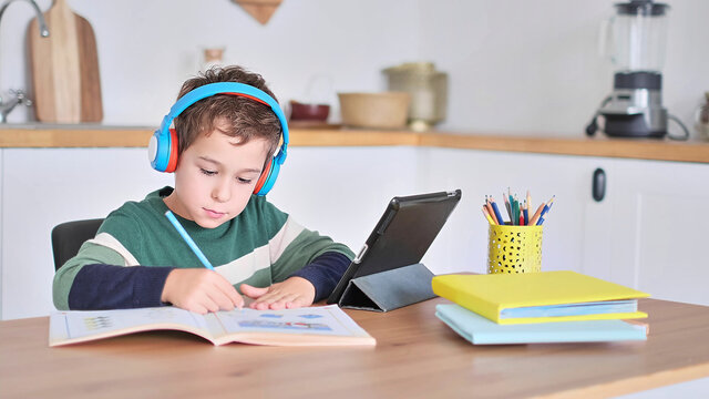 Smart boy student listen to online lesson on tablet wear headphones Spbas. Homeschooled child watch.