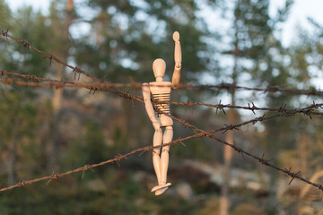 Wooden man and barbed wire, danger or unfreedom concept.