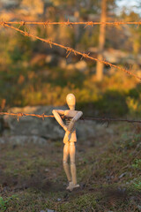 Wooden man and barbed wire, danger or unfreedom concept.