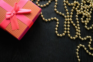beautiful gift wrapped with festive ribbon on a black wooden background