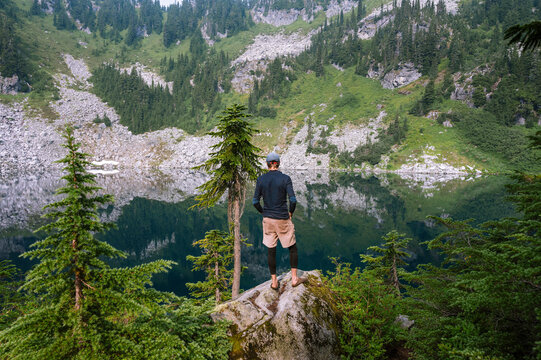 Hiker taking in the serene views of an alpine lake in washington