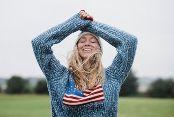 woman enjoying the windy outdoors in an American flag sweater