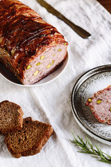 Terrine. Meatloaf. Traditional French cuisine loaf of meat, similar to a pâté, with bacon and pistachios. Selective focus