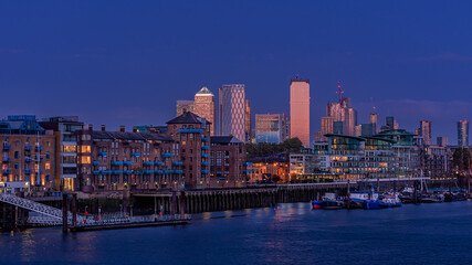 Fototapeta na wymiar Twilight above the Thames River in London with the skyscrapers of the Docklands district in the background