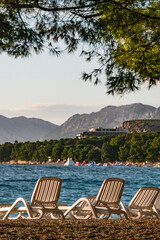 Makarska, Croatia, Beach chairs along the Adriatic sea and harbour around  the city.