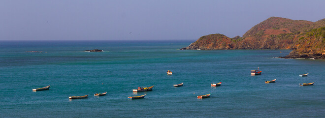 Multicolored fishing boats sway to the gentle swaying of the waves on a placid blue sea