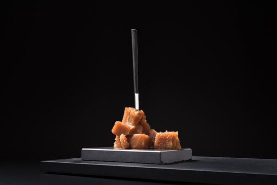 Gourmet quince jelly paste in ceramic plate on black background