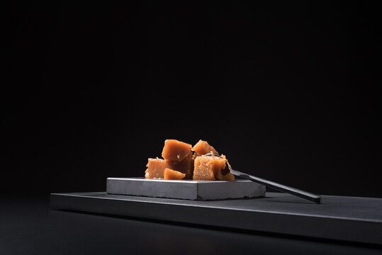 Gourmet quince jelly paste in ceramic plate on black background