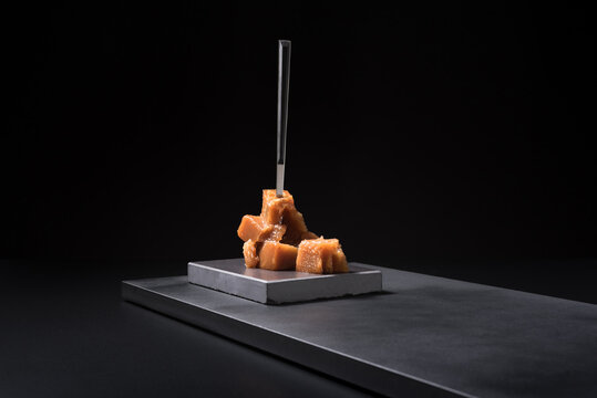 Gourmet quince jelly paste in ceramic plate on black background
