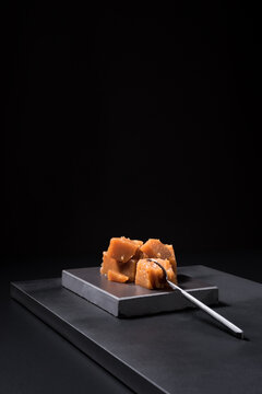 Gourmet quince jelly paste in ceramic plate on black background