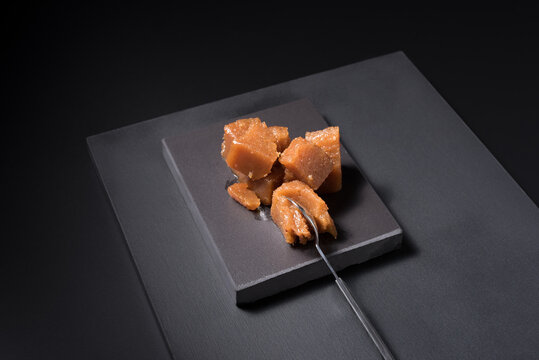 Gourmet quince jelly paste in ceramic plate on black background