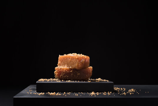 Gourmet quince jelly paste in ceramic plate on black background