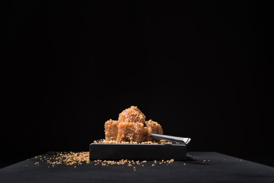 Gourmet quince jelly paste in ceramic plate on black background