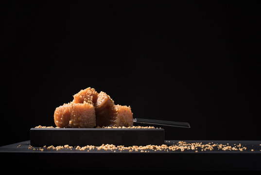 Gourmet quince jelly paste in ceramic plate on black background