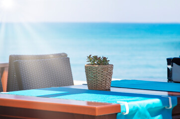 luxury swimming pool. Good morning! potted flower on table with sun and defocused natural turquoise sea background