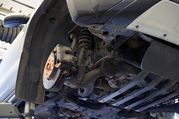 A modern powerful car in a car service on a lift. Service, repair, spare parts. Selected focus.