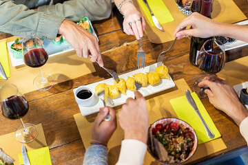 Top view of friends eating steamed ravioli and hawaiian pokes at sushi bar restaurant - Food...