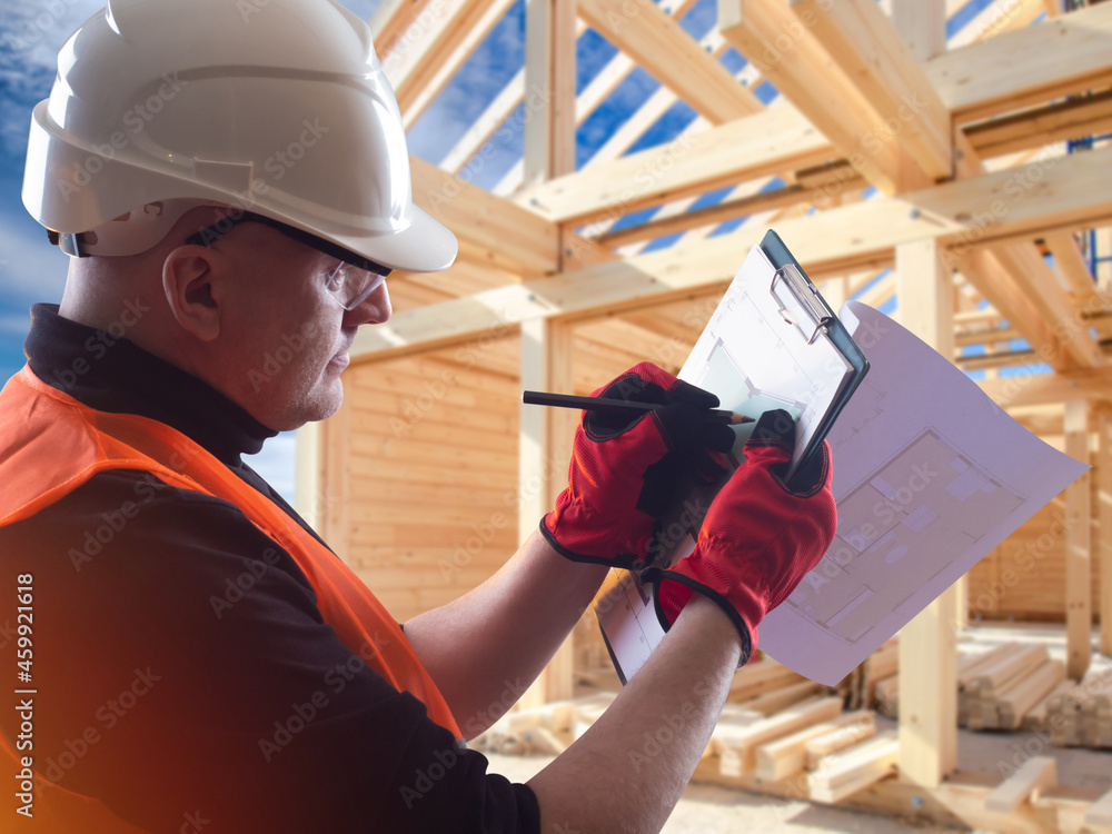 Aufkleber a builder next to wooden house. timber frame behind architect. man draws construction drawings. arch