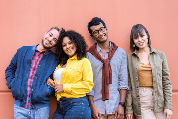 Multiracial friends group having fun at wall on university college campus - Diverse culture students portrait celebrating outside - Young smiling people looking at the camera for a group photo - obrazy, fototapety, plakaty